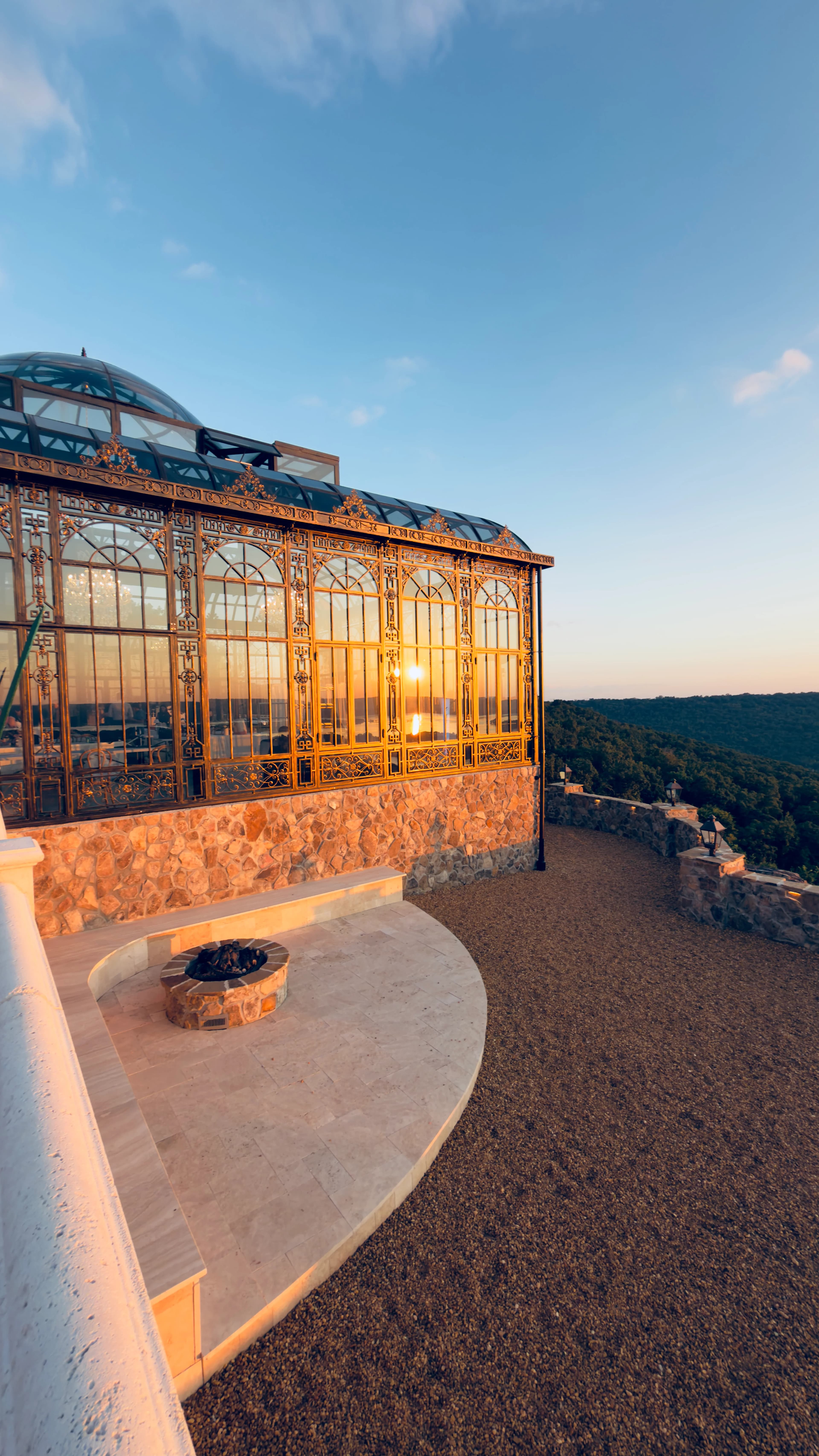 Stone Haven glass conservatory at golden hour overlooking the Tennessee River valley.