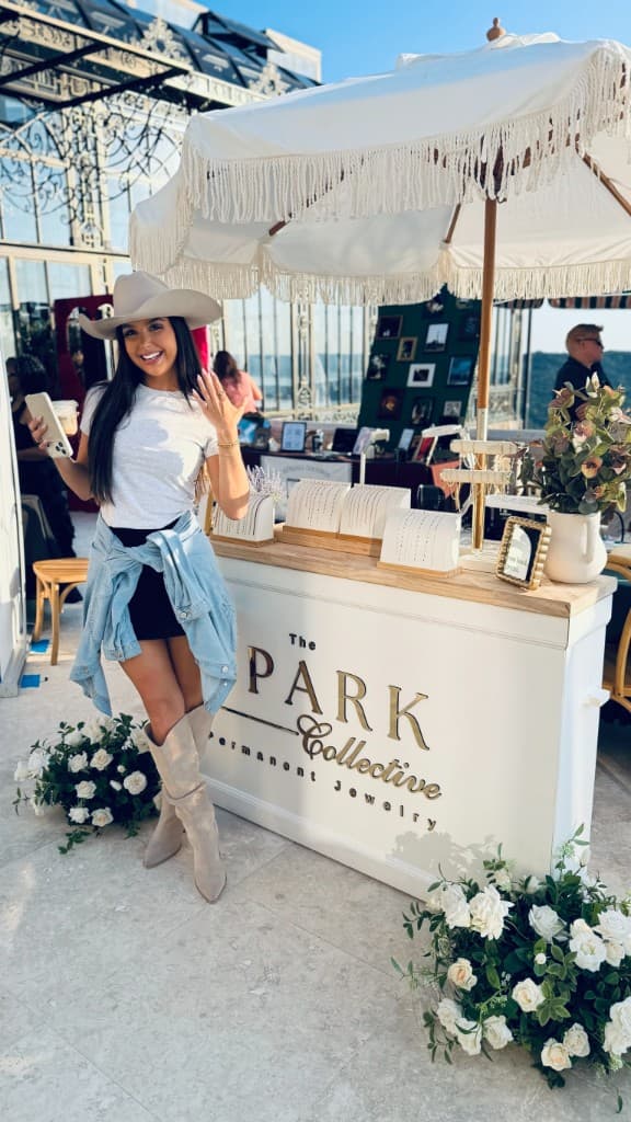 A guest at the Stone Haven Bridal Expo showing her permanent jewelry ring at The Spark Collective booth.